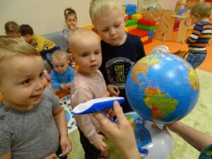 Trójka dzieci stoi obok globusa