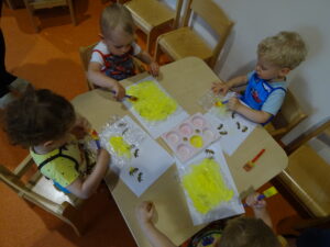 Dzieci smarują folie żółta farbą