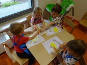 Dzieci nabierają farbe na pędzelki