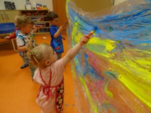 Dzieci z zaciekaiweniem malują folię