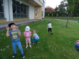 Dzieci biegają za bańkami mydlanymi
