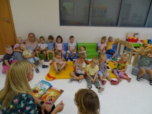 Opiekunka czyta dzieciom wierszyk