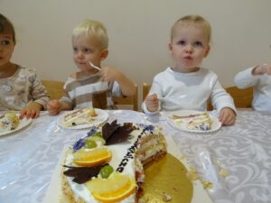 Dziewczynki oraz chłopiec jedzą tort