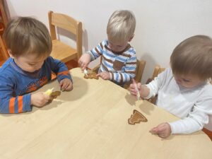 Troje dzieci dekoruje pierniczki