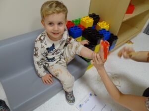 Opiekunka maluje chłopczykowi stopę farbą