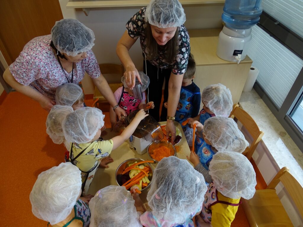 Dzieci robią sok z opiekunami