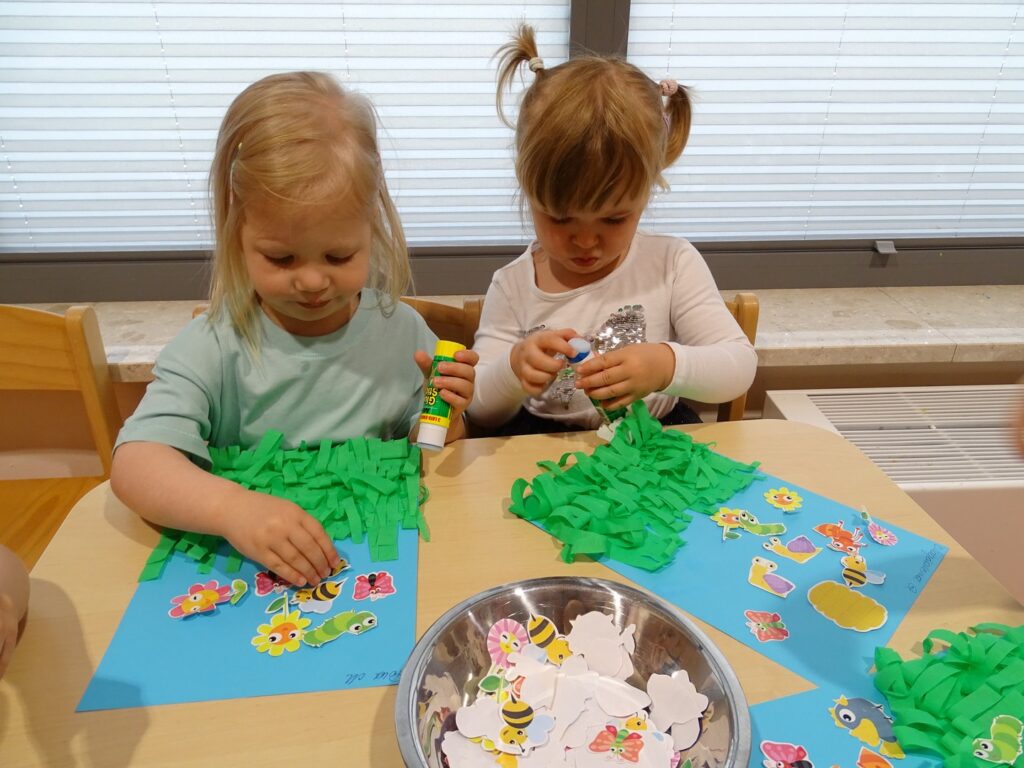 Dziewczynki przyklejają obrazki owadów