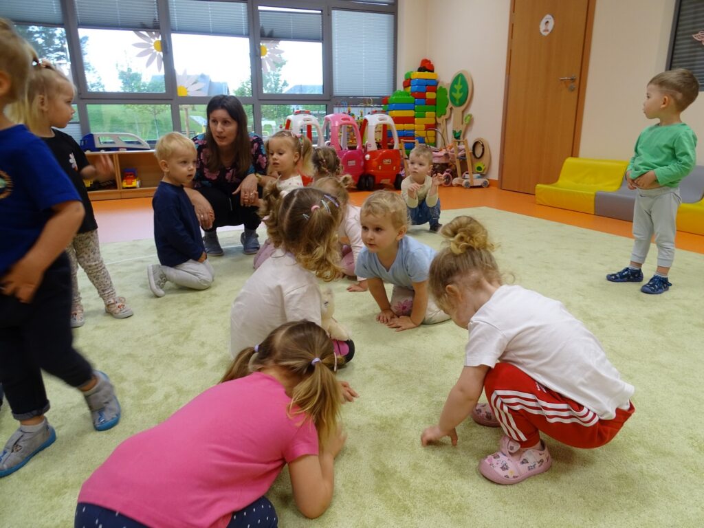 Dzieci kucają na dywanie