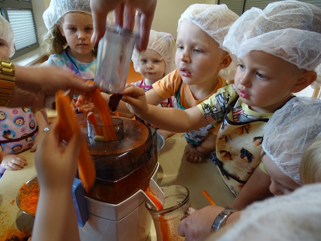 Dzieci wkładają marchewki