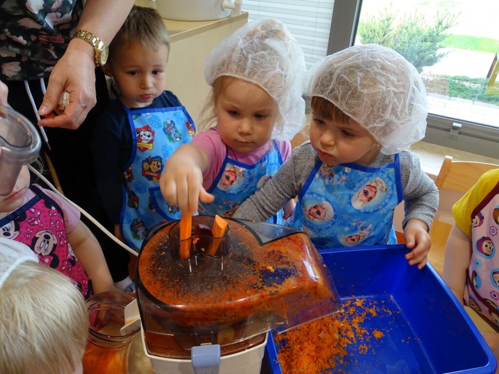 Dziewczynki wkładają kawałki marchewki
