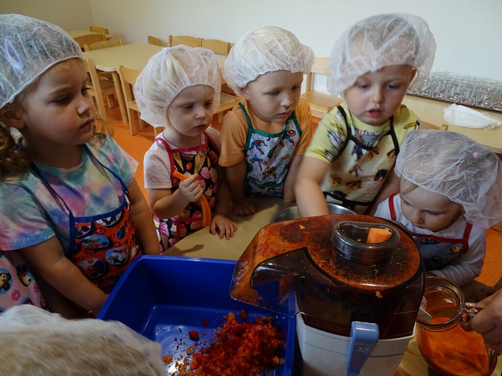 Dzieci stoją przy sokowirówce