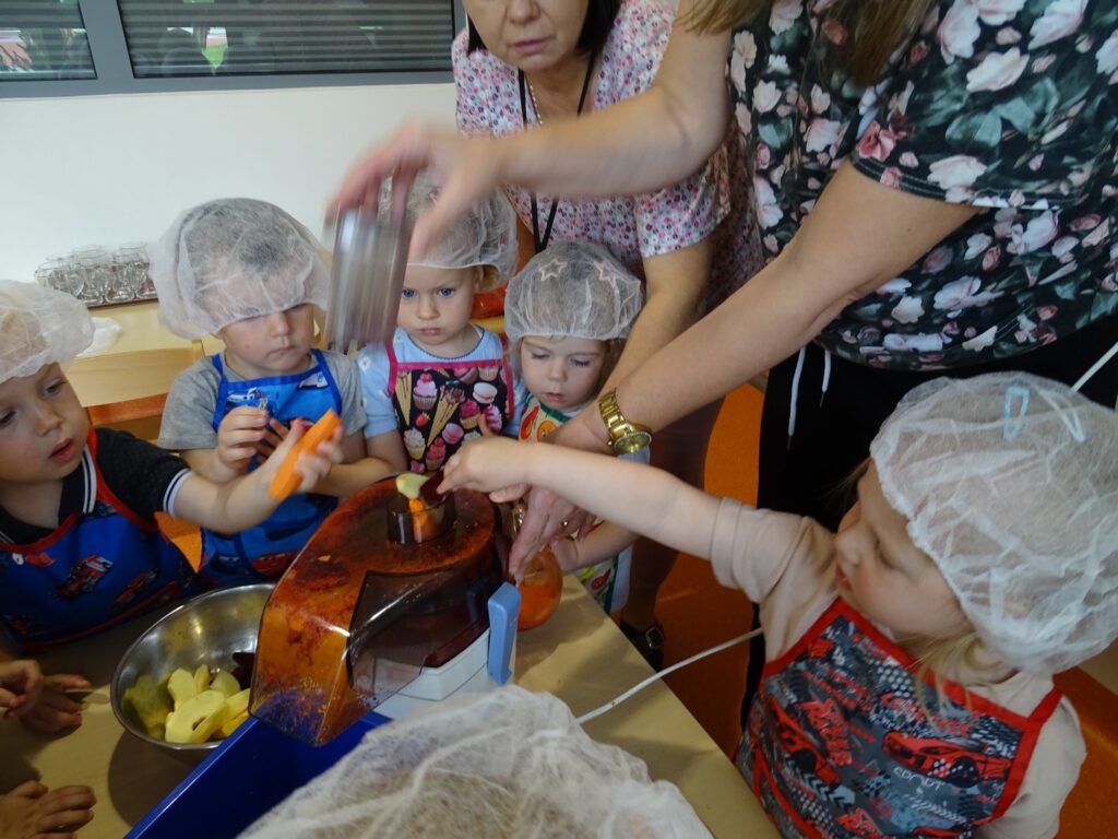 Dzieci stoją przy sokowirówce