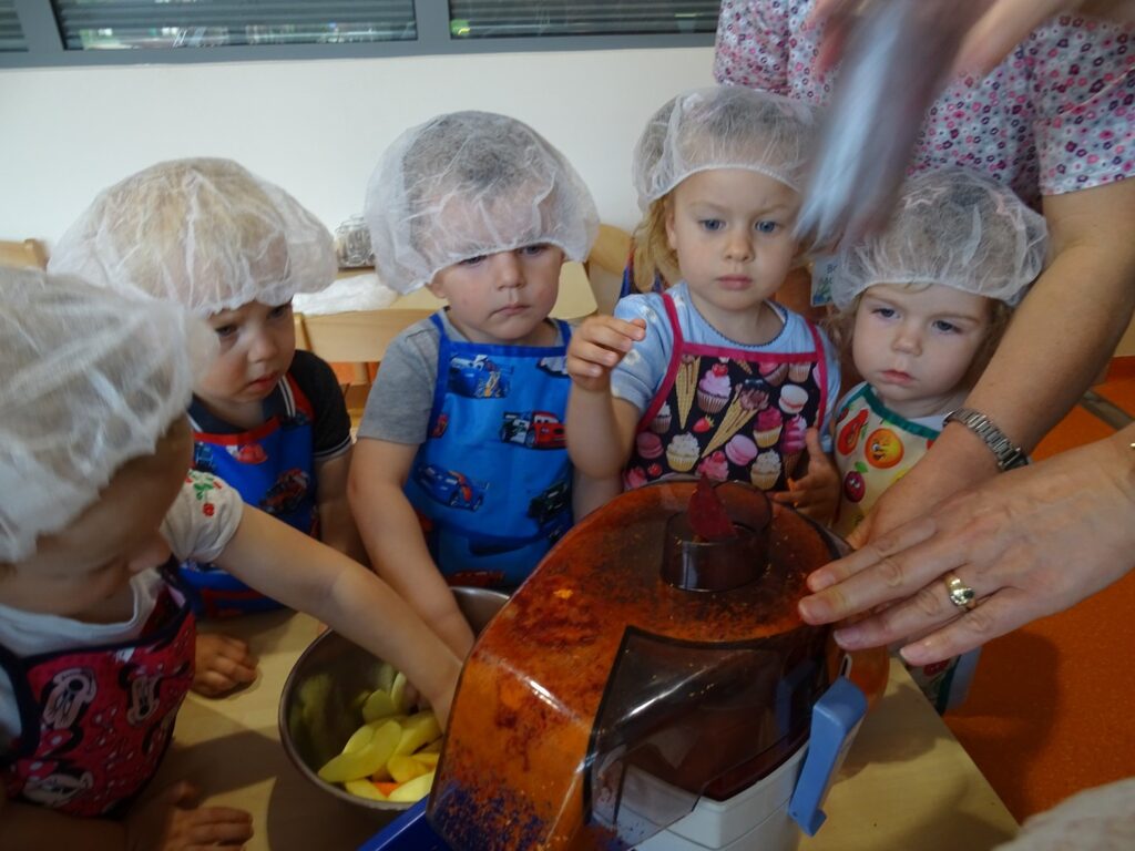 Dzieci sięgają po jabłka