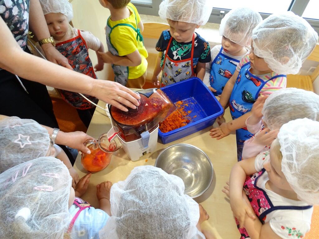 Dzieci patrzą jak działa sokowirówka