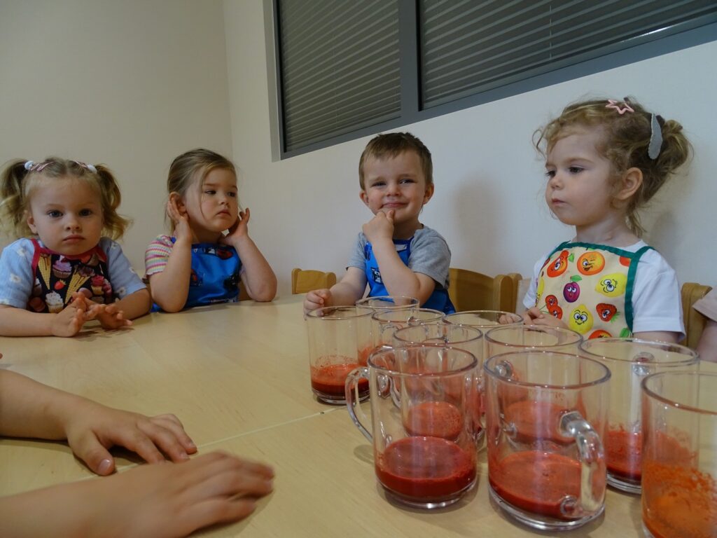 Dzieci siedzą przy stolikach