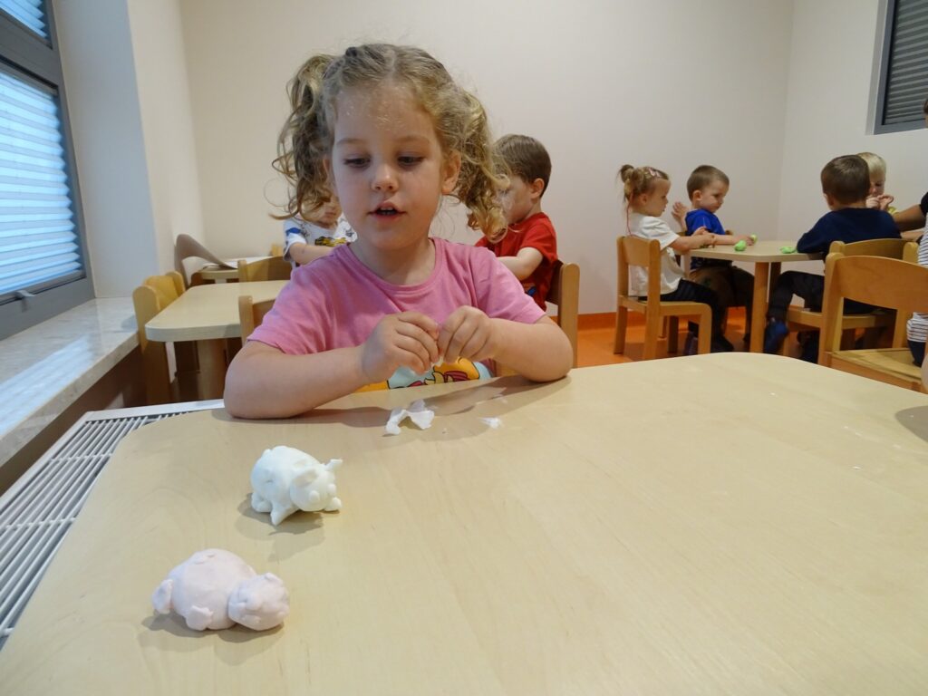 Dziewczynka lepi z białej plasteliny