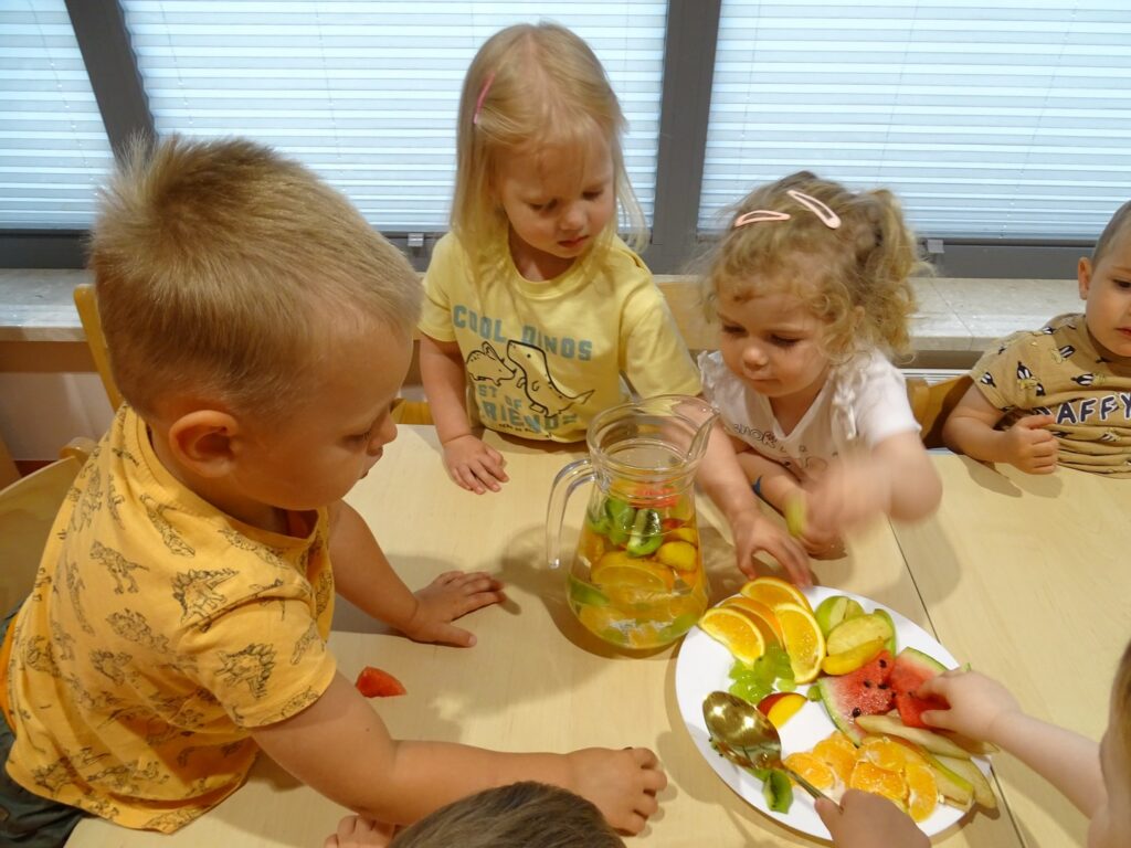 Dziewczynka wrzuca owoce do dzbanka