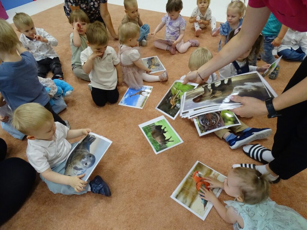 Dzieci z zainteresowaniem oglądają zdjęcia zwierząt