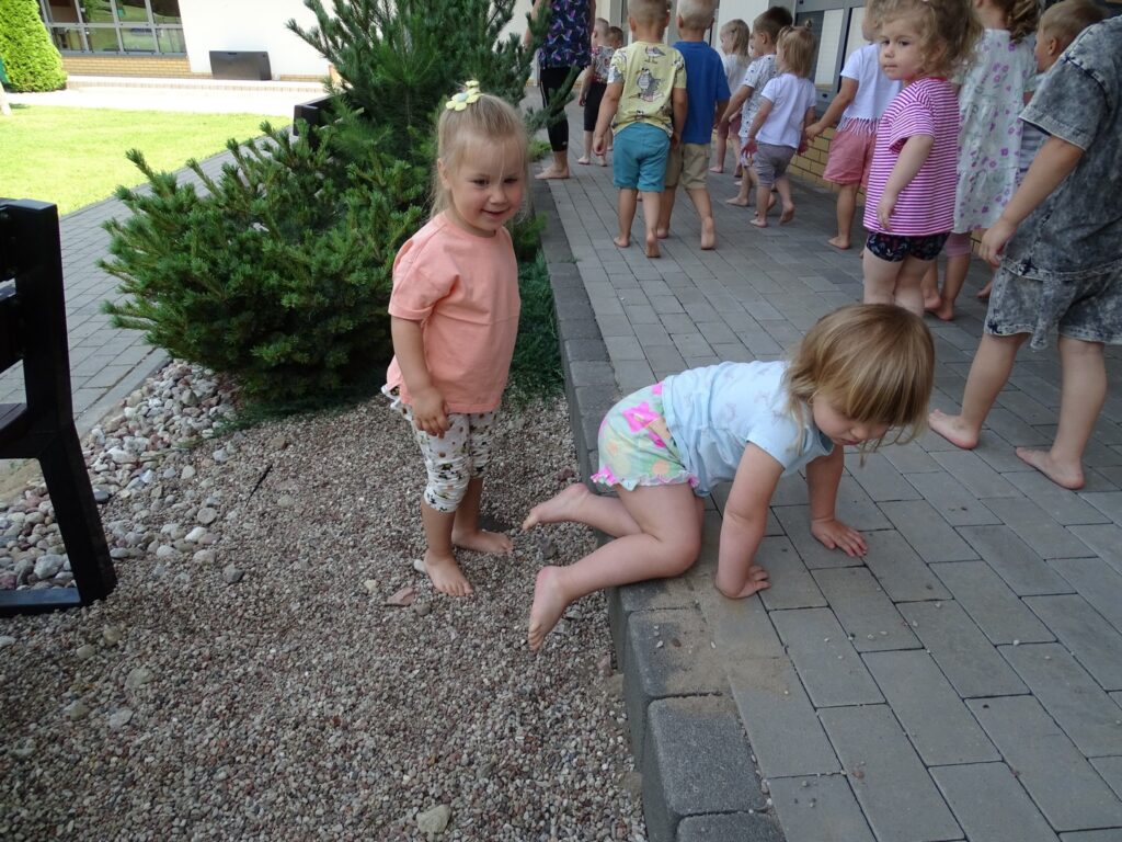 Dziewczynka stoi boso na kamyczkach