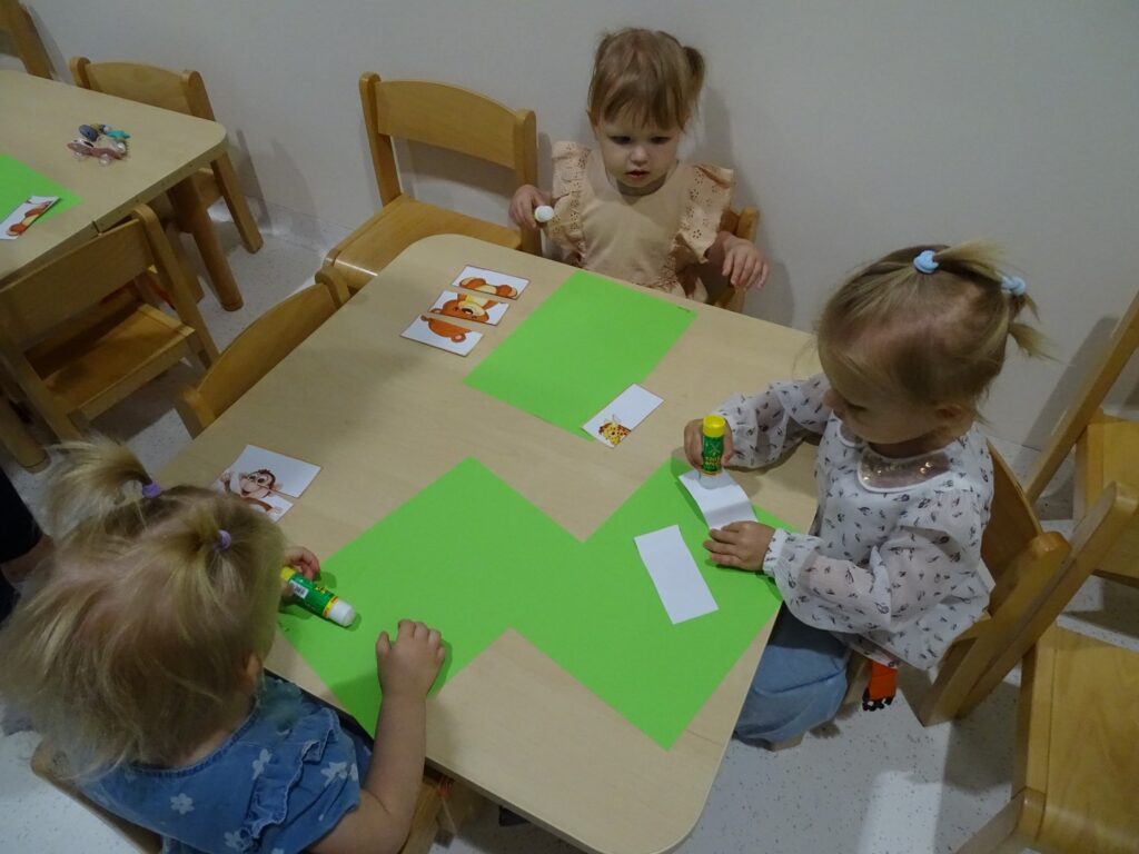 Dziewczynka smaruje obrazek klejem