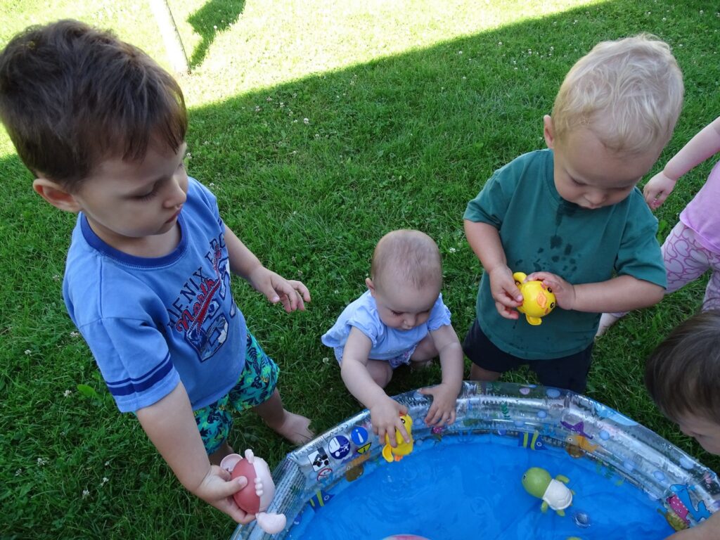 Dziewczynka wrzuca kaczuszkę do wody