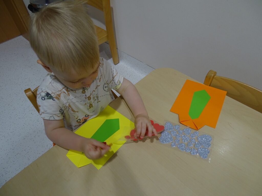 Chłopczyk nakleja serduszka