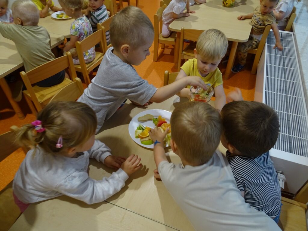 Chłopiec wrzuca owoce do dzbanka