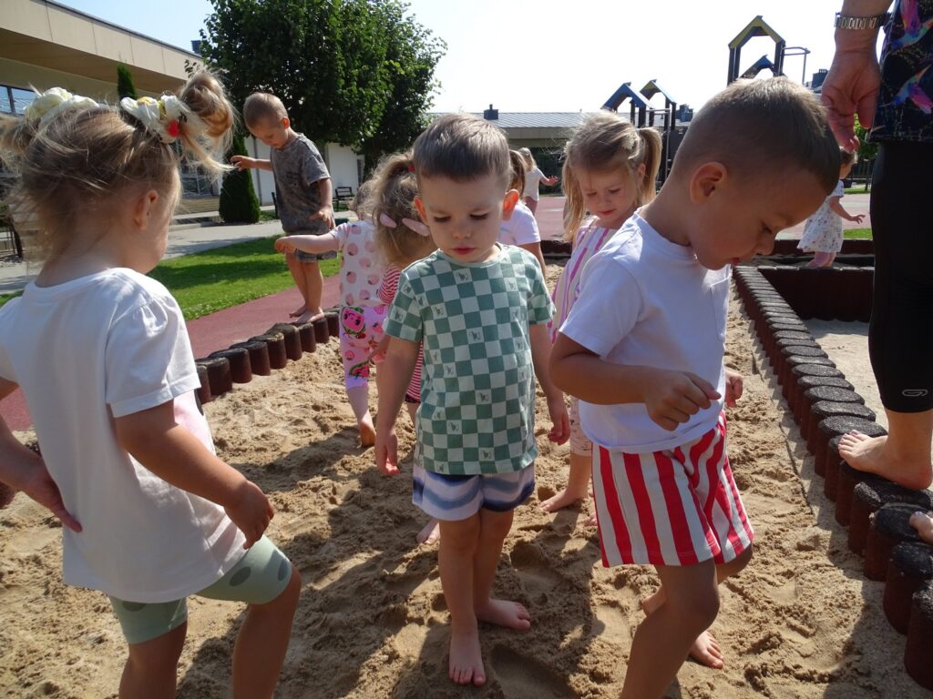 Dzieci chodzą po piasku