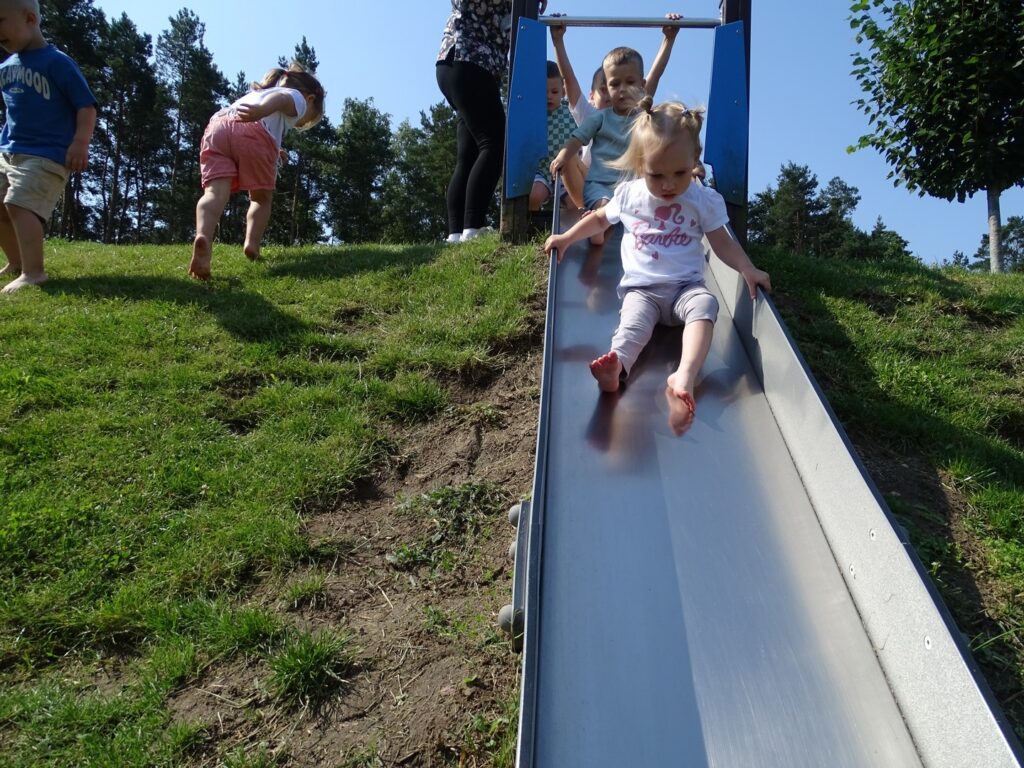 Dziewczynka siedzi na zjeżdżalni