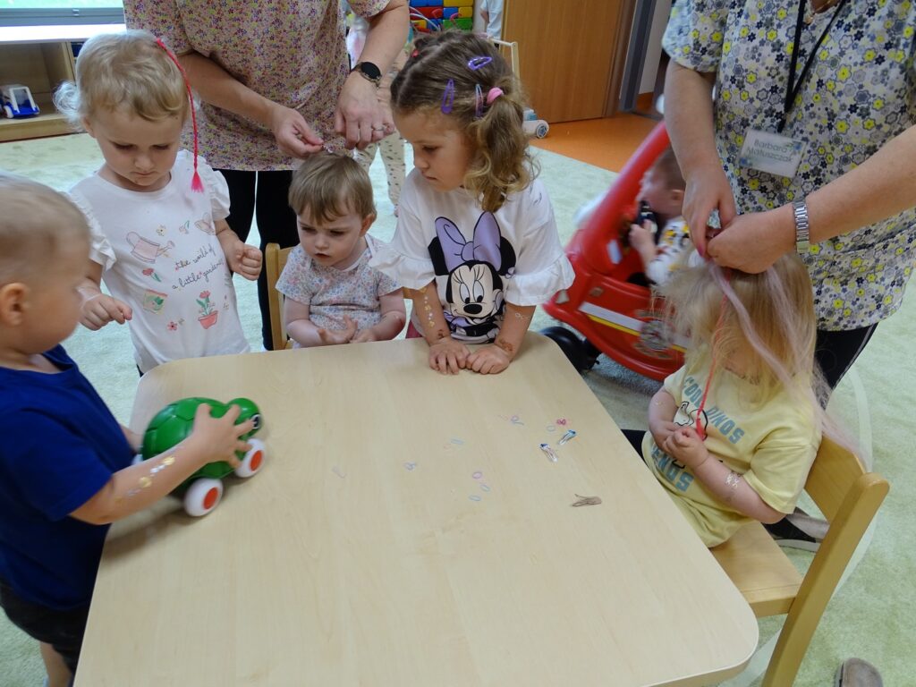 Opiekunowie zaplatają warkoczyki