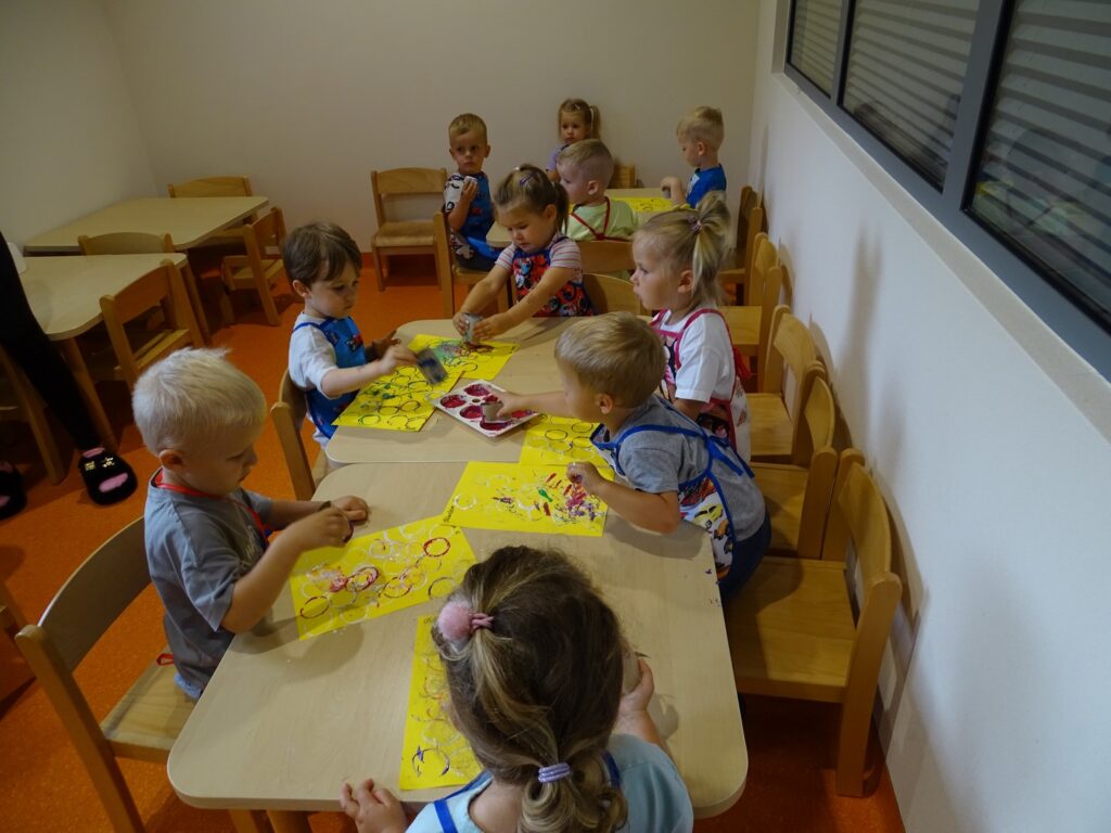 Dzieci siedzą przy stolikach