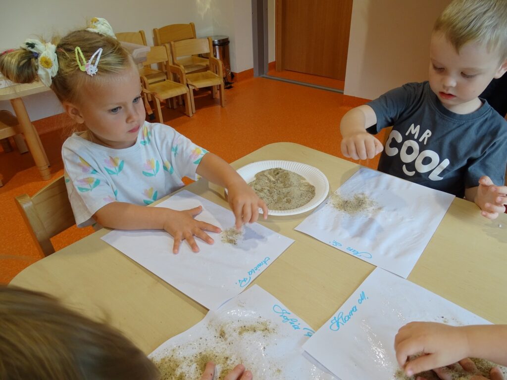 Chłopczyk sypie piasek