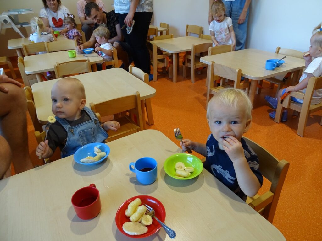 Chłopcy jedzą przy stoliku