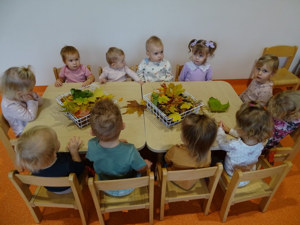 Dzieci siedzą przy stolikach