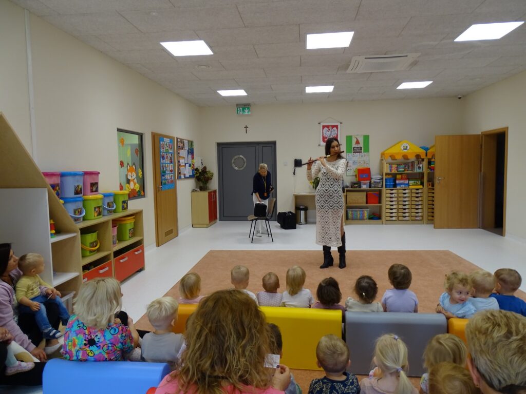 Dzieci słuchają jak pani gra na flecie