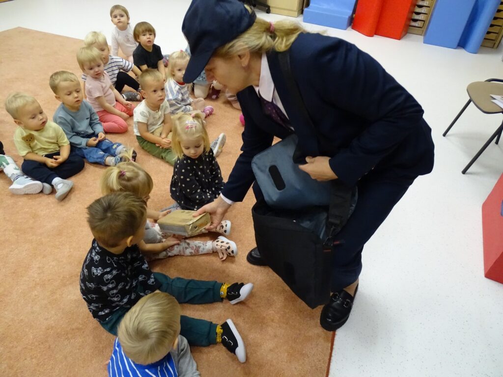 Listonoszka wręcza dziewczynce paczkę