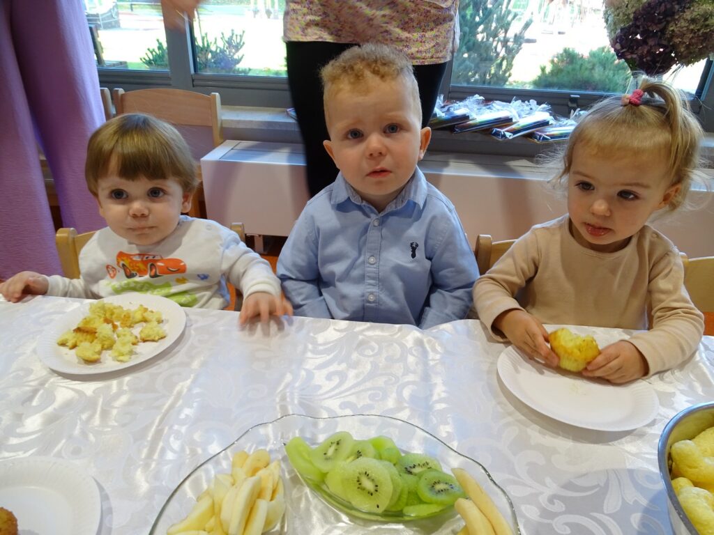 Dziewczynka z chłopcami przy stoliku