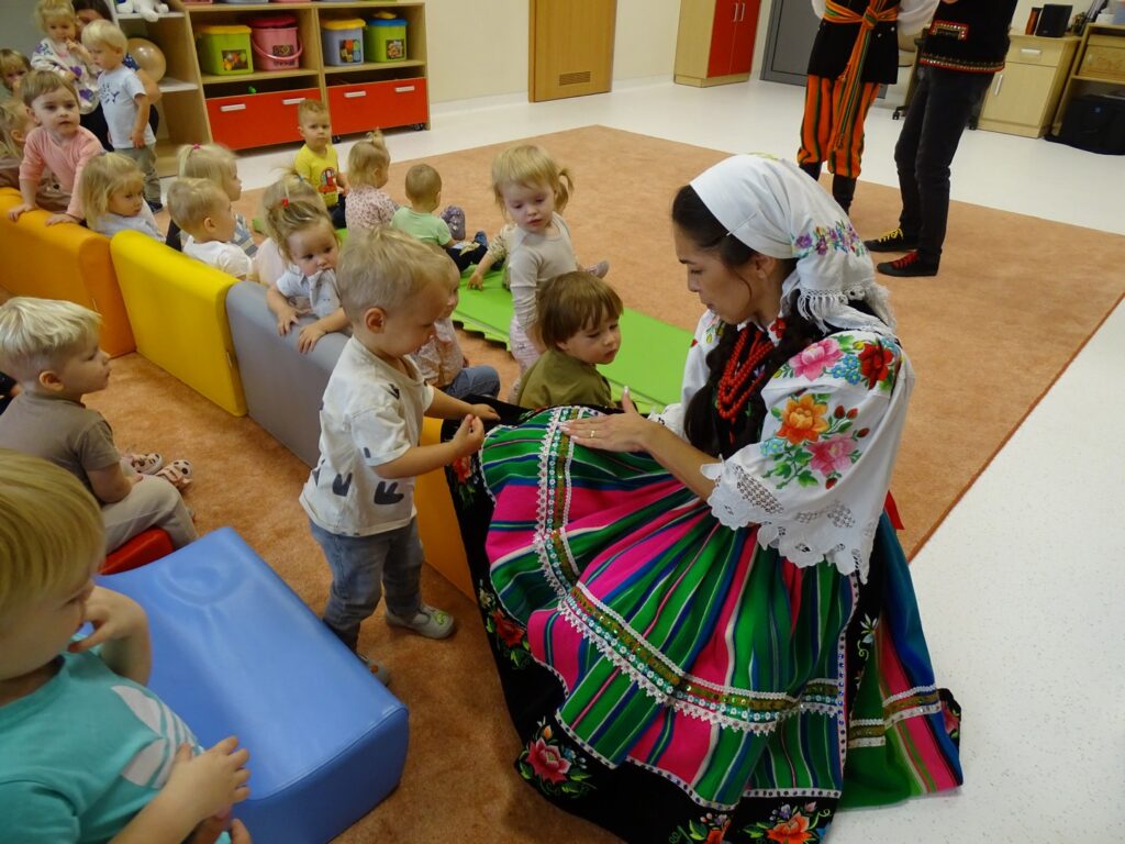 Dzieci oglądają wyszywaną spódnicę