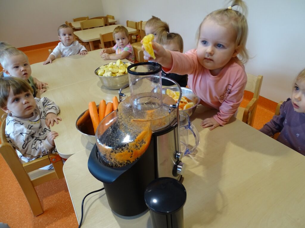 Dziewczynka wrzuca kawałek pomarańczy