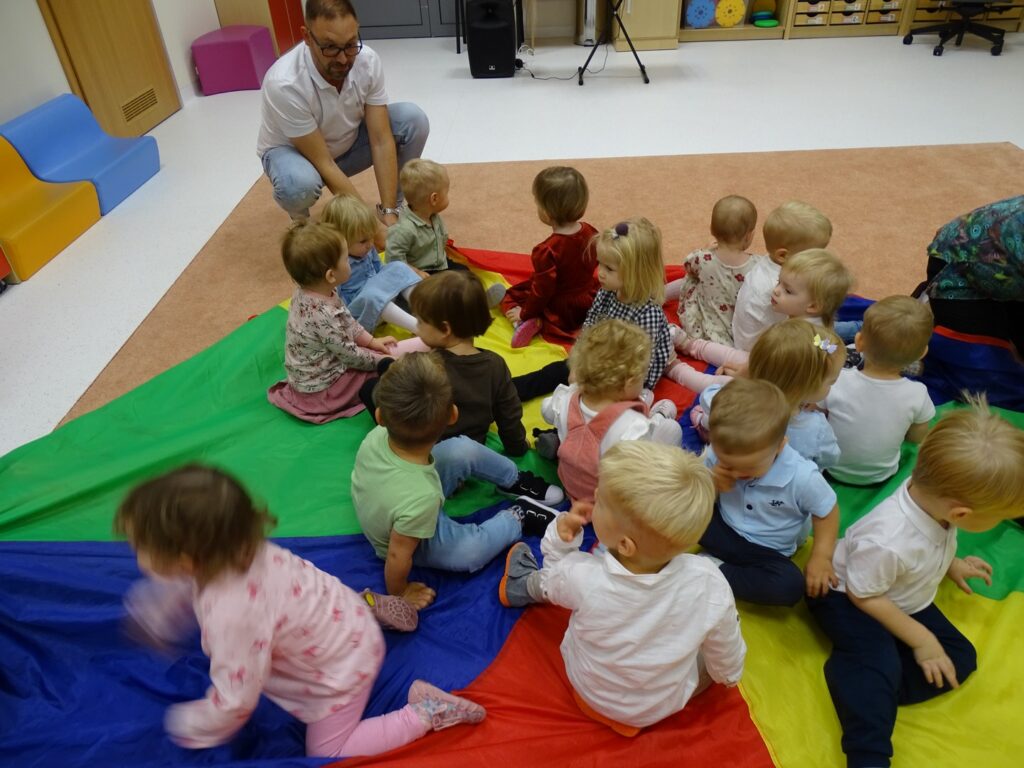 Dzieci siedzą na chuście animacyjnej