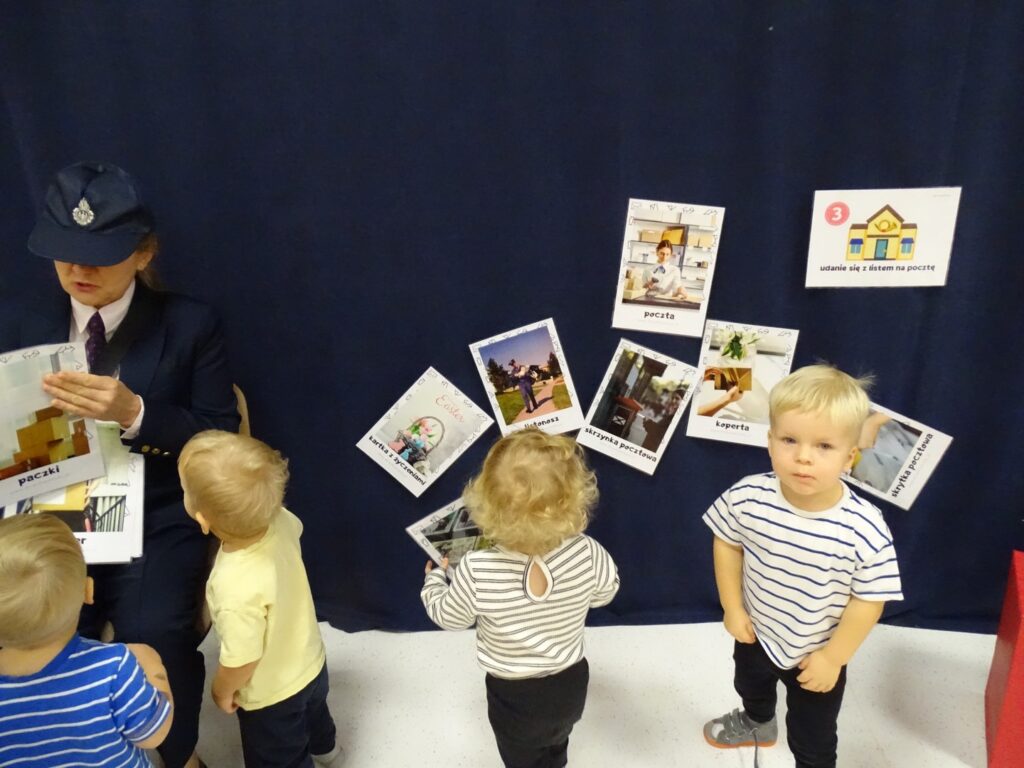 Dzieci oglądają karty o pracy listonosza i poczcie
