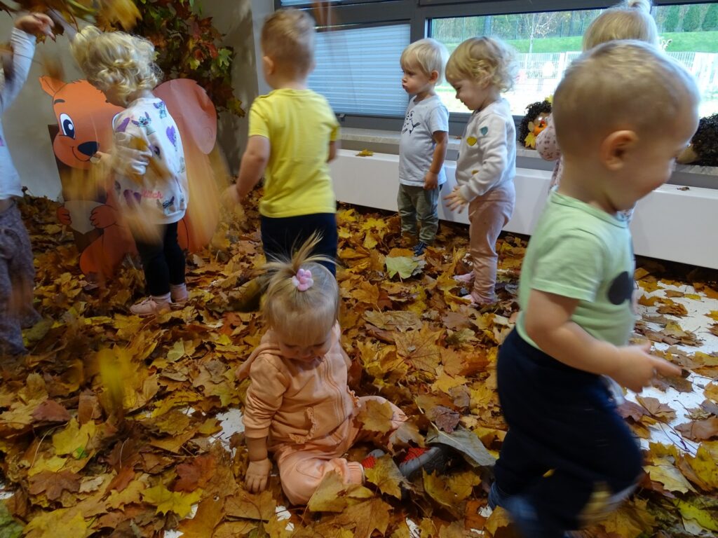Dziewczynka bawi się w liściach