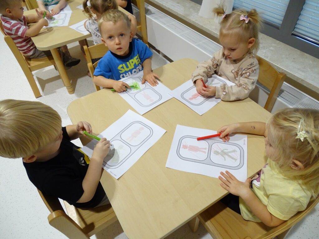 Dzieci malują obrazek kredkami