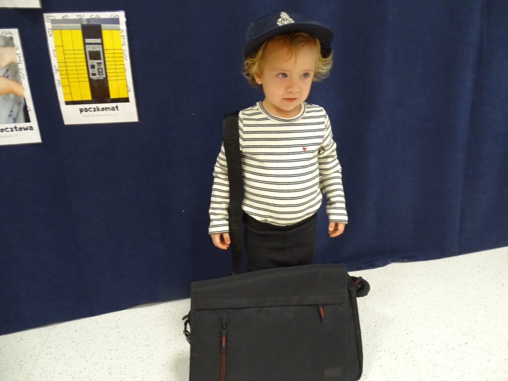 Dziewczynka pozuje w czapce listonosza