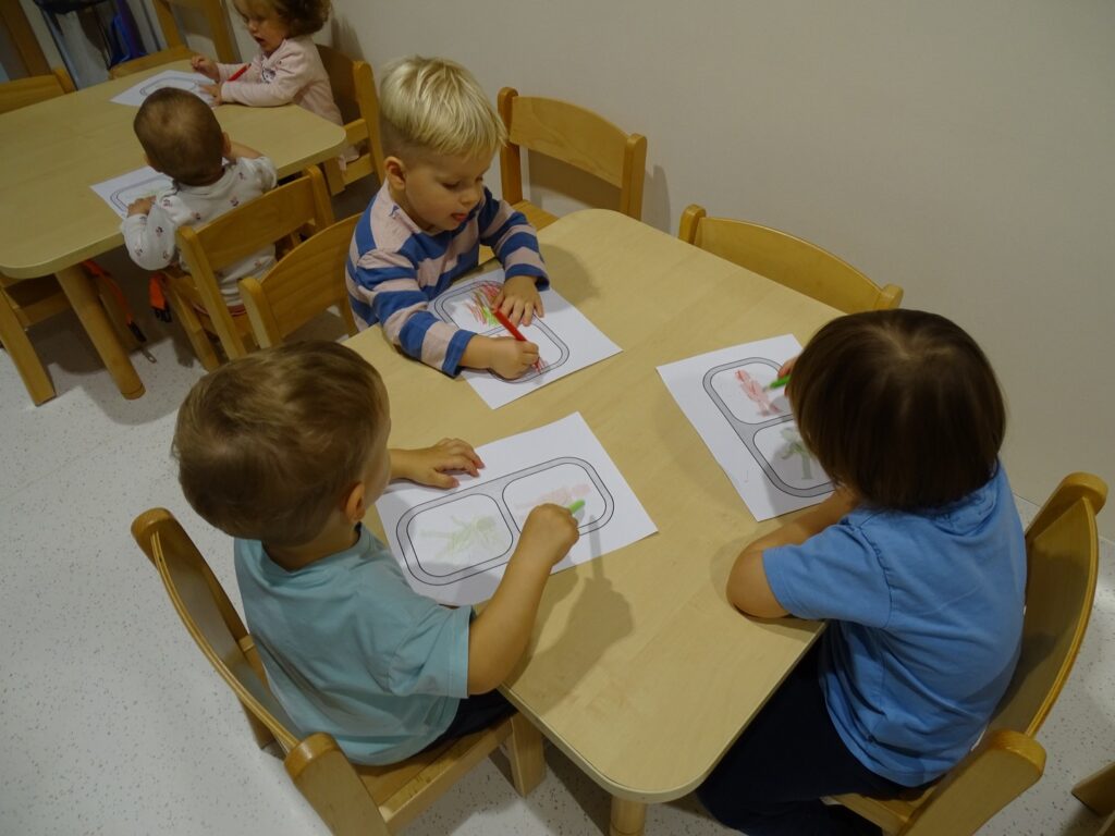 Chłopcy malują kredkami