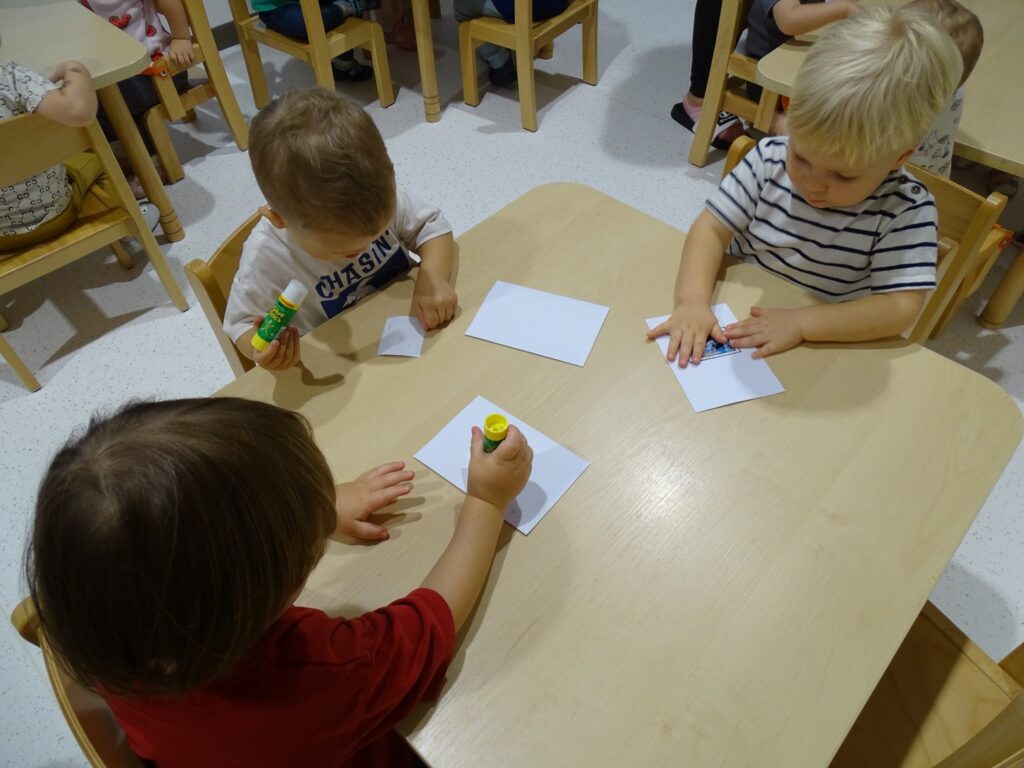 Chłopcy smarują znaczek klejem