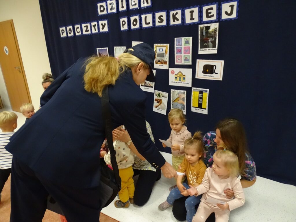 Pani listonosz rozdaje dzieciom listy