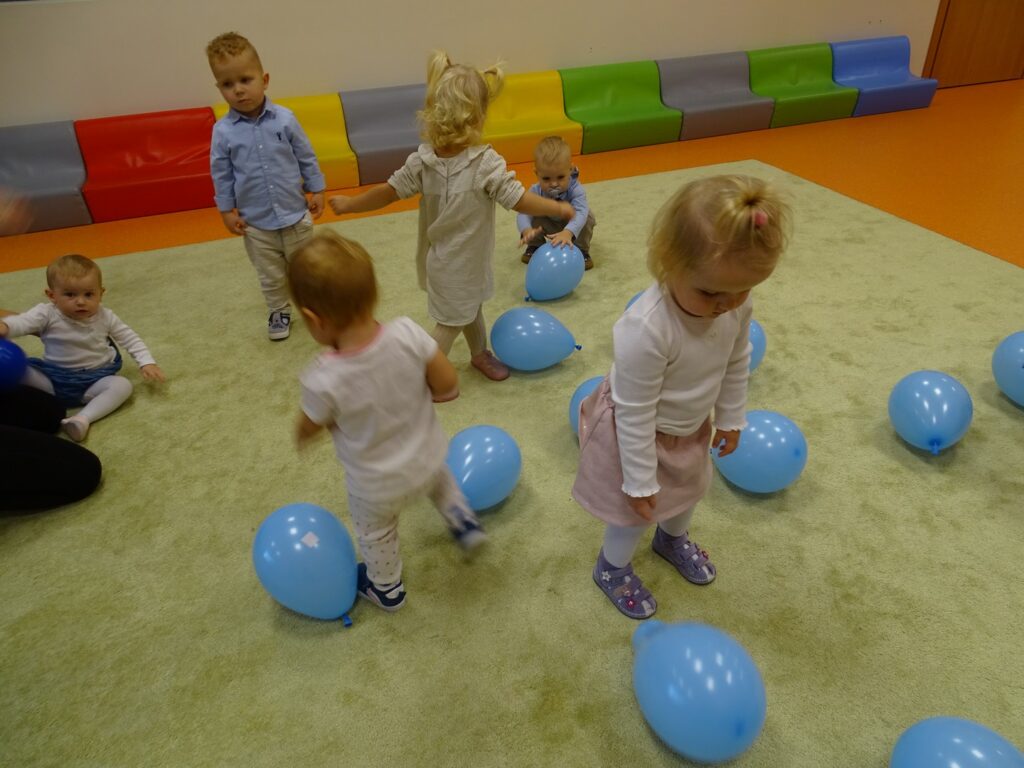 Dzieci bawią się balonami na dywanie