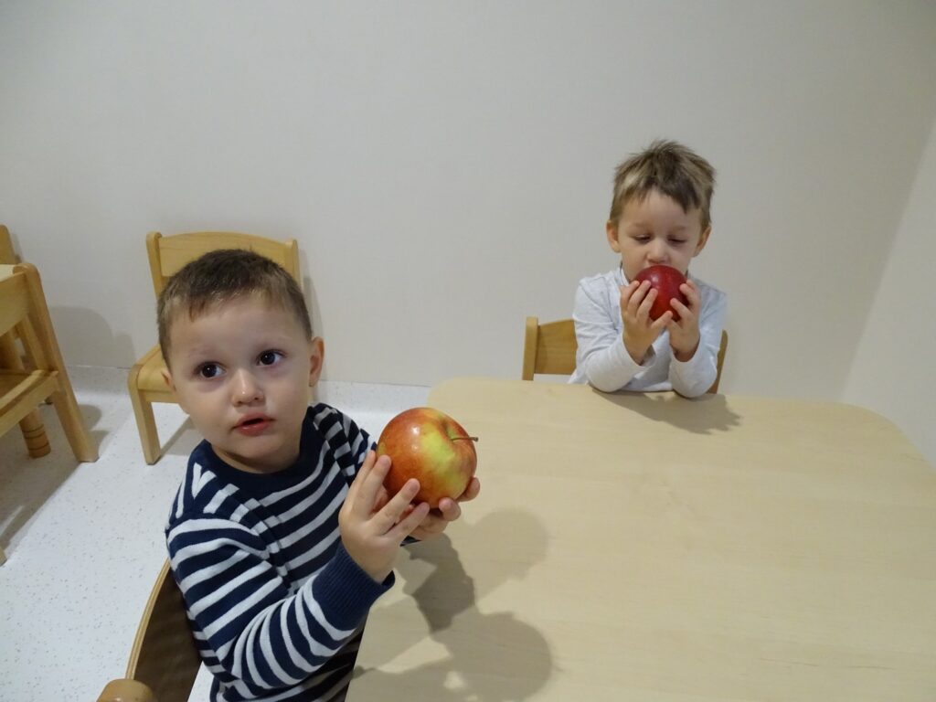 Chłopcy trzymają jabłuszka