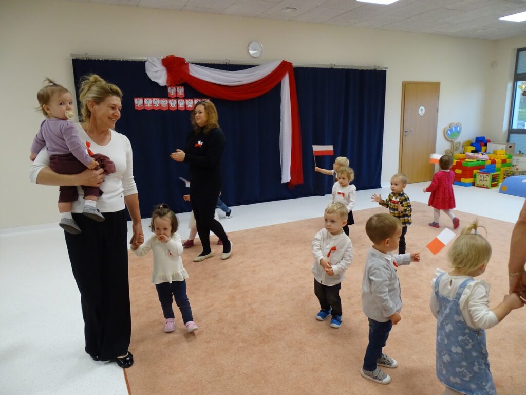 Dzieci chodzą i słuchają patriotycznych piosenek